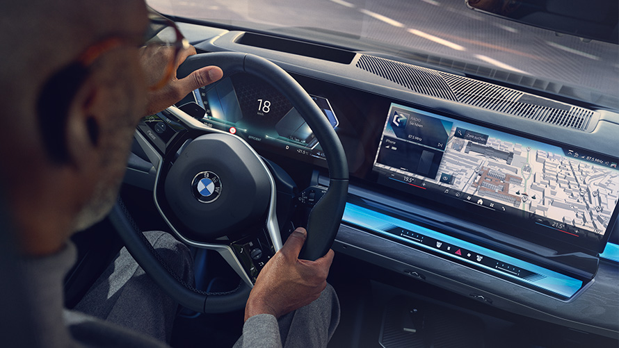 BMW invändig utrustning man tittar på displayen med Operating System 8.5 BMW invändig utrustning man tittar på BMW Maps på displayen med Operating System 8.5