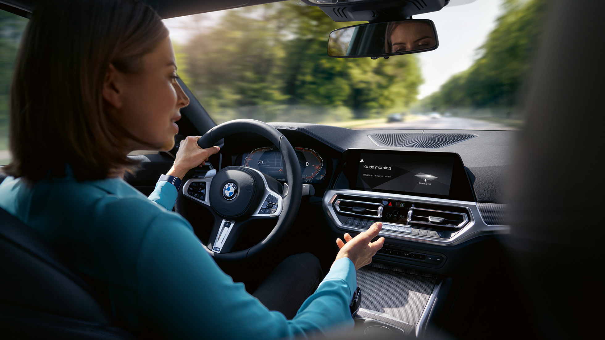 Kvinna använder BMW Intelligent Personal Assistant i sin BMW Kvinna använder Intelligent Personal Assistant som ingår i BMW ConnectedDrive-paketet i hennes BMW