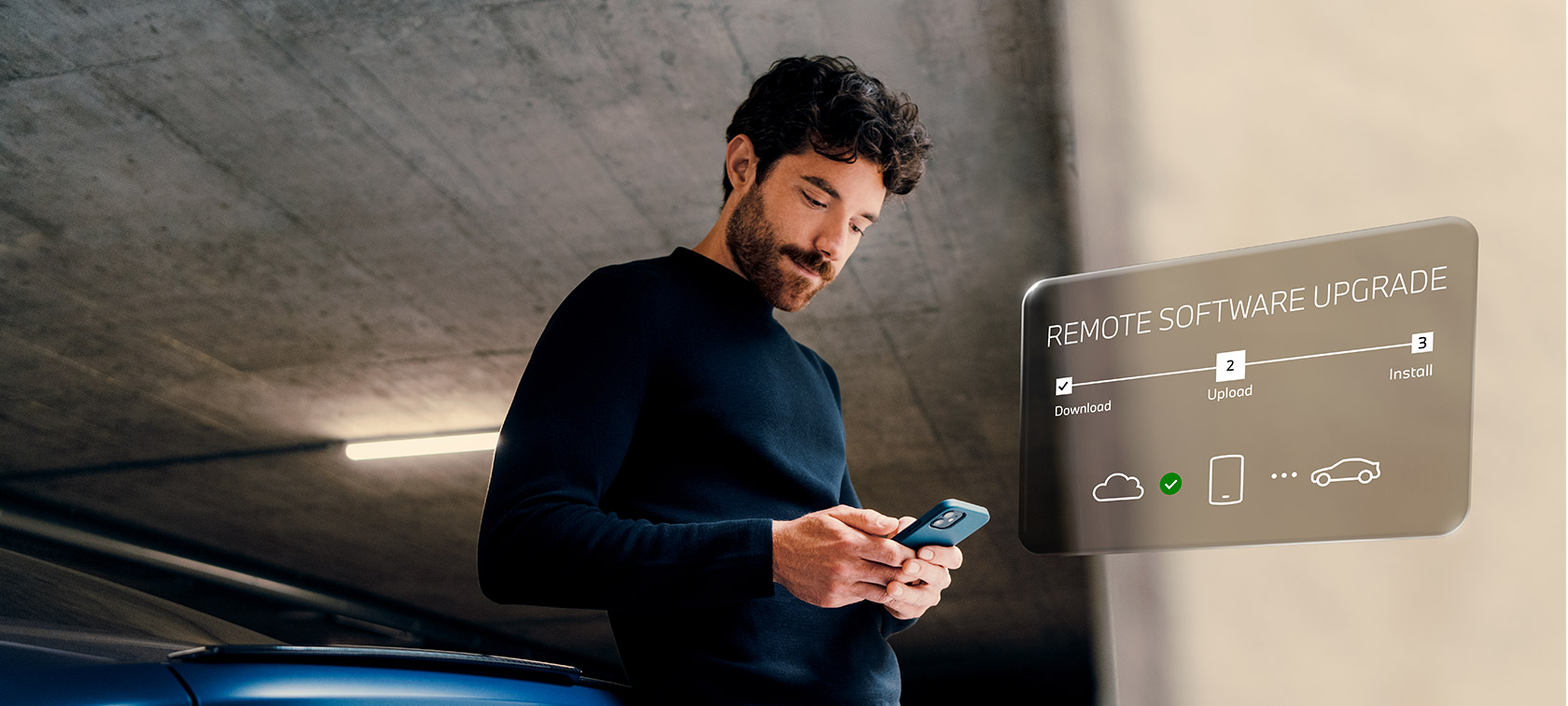 En man står framför BMW och tittar på sin smartphone Remote Software Upgrade en man står framför en BMW och tittar på sin smartphone