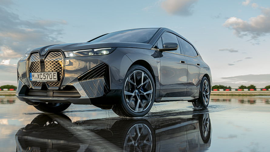 BMW Original lättmetallfälgar, BMW iX (i20) snett framifrån på våt väg BMW Original lättmetallfälgar, BMW iX (i20) snett framifrån på våt väg