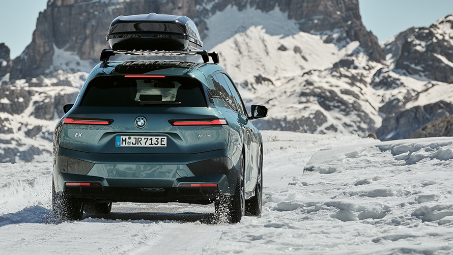 BMW kompletta vinterhjul på BMW iX (I20) på snötäckt väg med berg i bakgrunden BMW kompletta vinterhjul på BMW iX (I20) på snötäckt väg med berg i bakgrunden