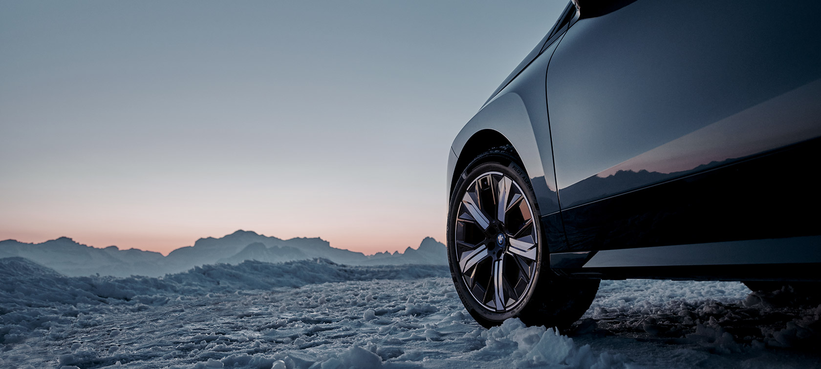 BMW Original fälgar på BMW iX (I20) i snö med berg i bakgrunden BMW Original fälgar på BMW iX (I20) i snö med berg i bakgrunden