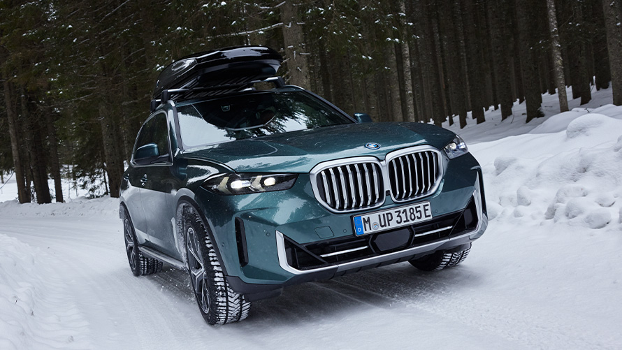BMW kompletta vinterhjul på BMW X5 (G05 LCI) på snöbelagd väg i skogen BMW kompletta vinterhjul på BMW X5 (G05 LCI) på snöbelagd väg i skogen