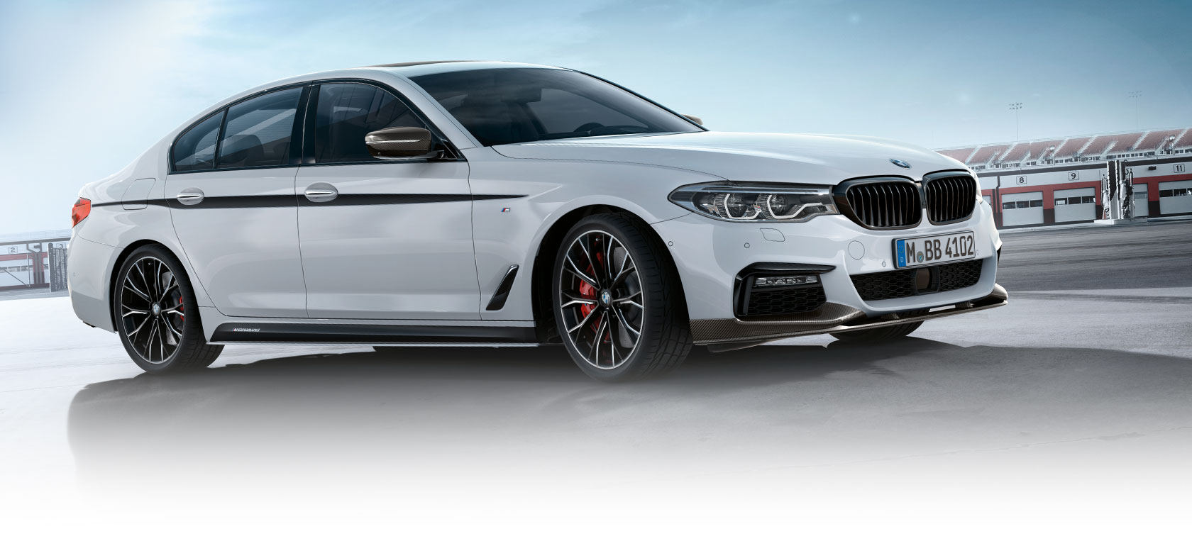 BMW 3-serie Limousine, M Performance Parts. Sidovy på BMW 3-serie Limousine på en parkeringsplats och under blå himmel.