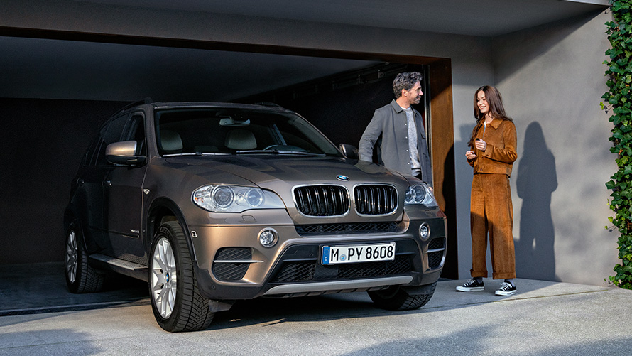 BMW står framför ett garage med modeller BMW Service 4+ en BMW står framför ett garage med modeller