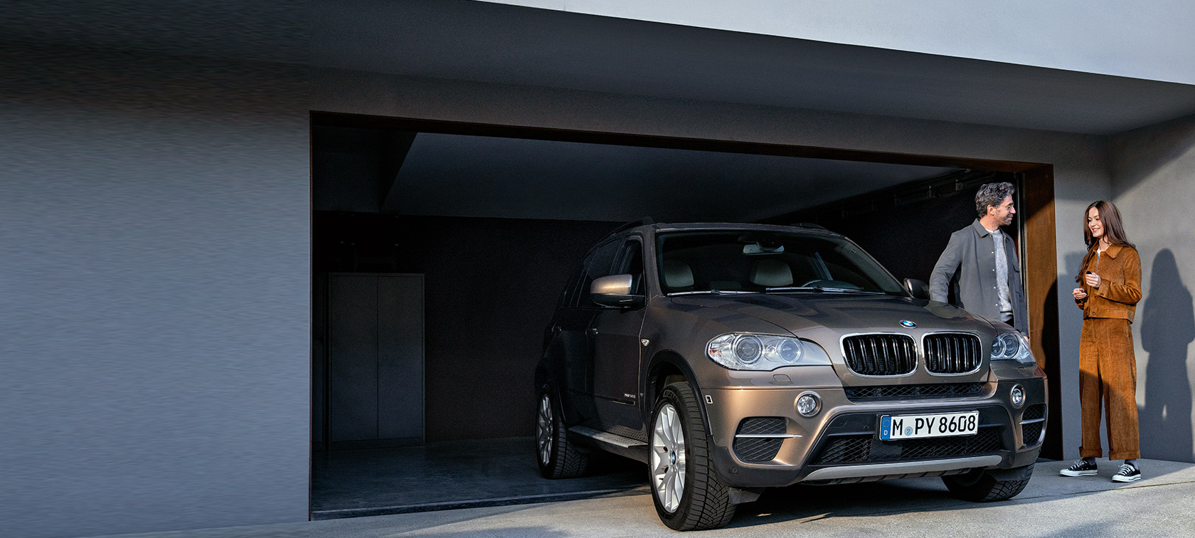 BMW Service 4+ BMW Service 4+ en man och en kvinna framför ett garage med en BMW X5