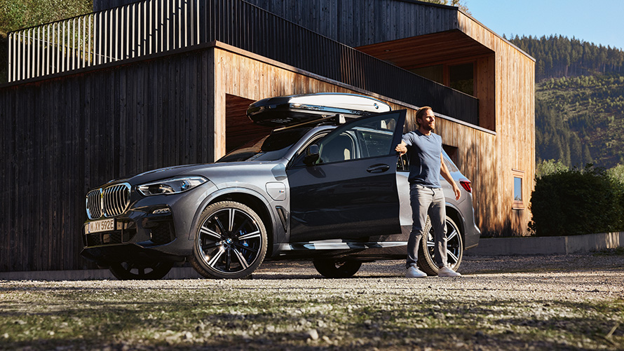 Man kliver ur sin BMW i sommarmiljö. Man kliver ur sin BMW i sommarmiljö.