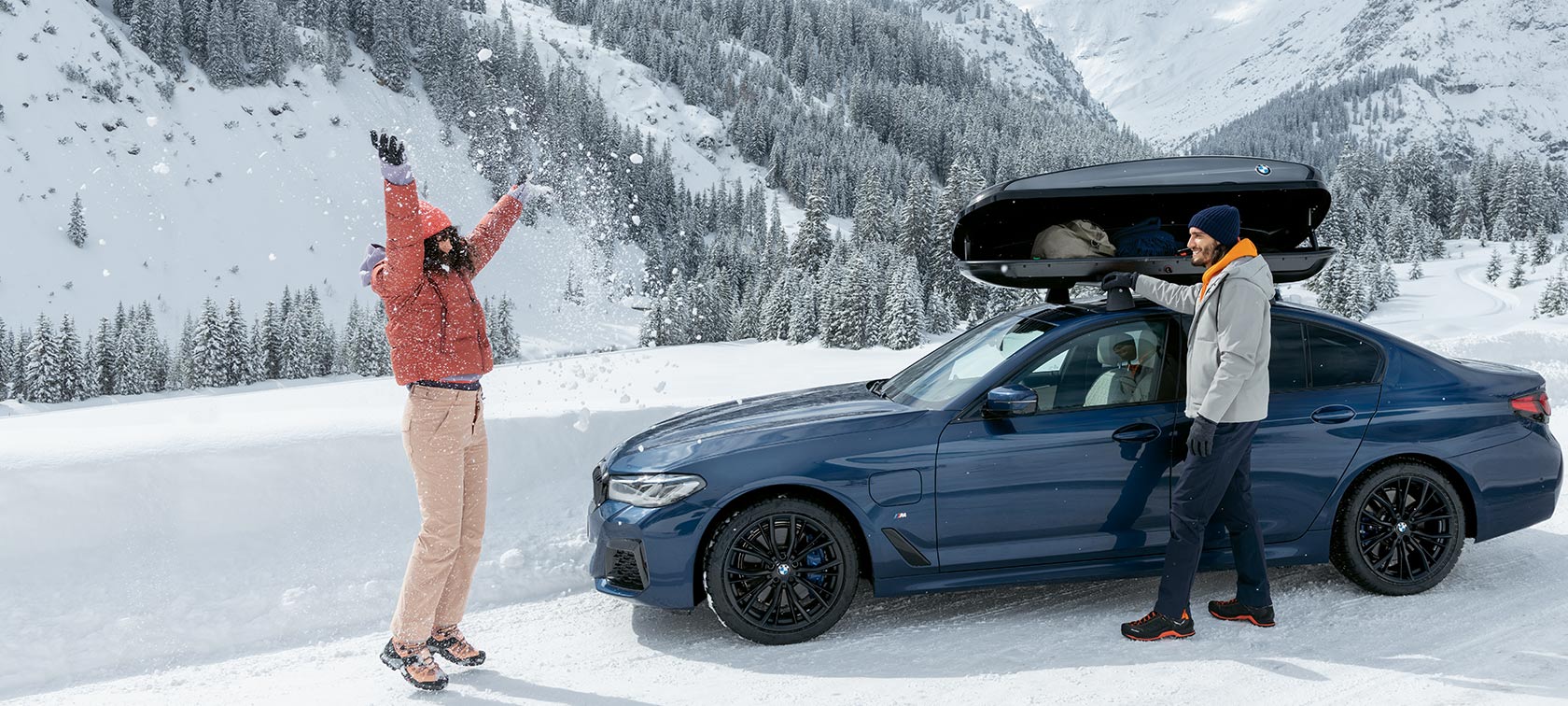 BMW Originaltillbehör och BMW Service för höst och vinter. Kvinna och man som skrattar på rodeldäck i snön