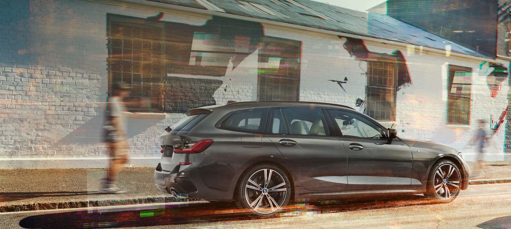 BMW 3-serie Touring, sedd från sidan under körning BMW 3-serie Touring, sedd från sidan framför hus