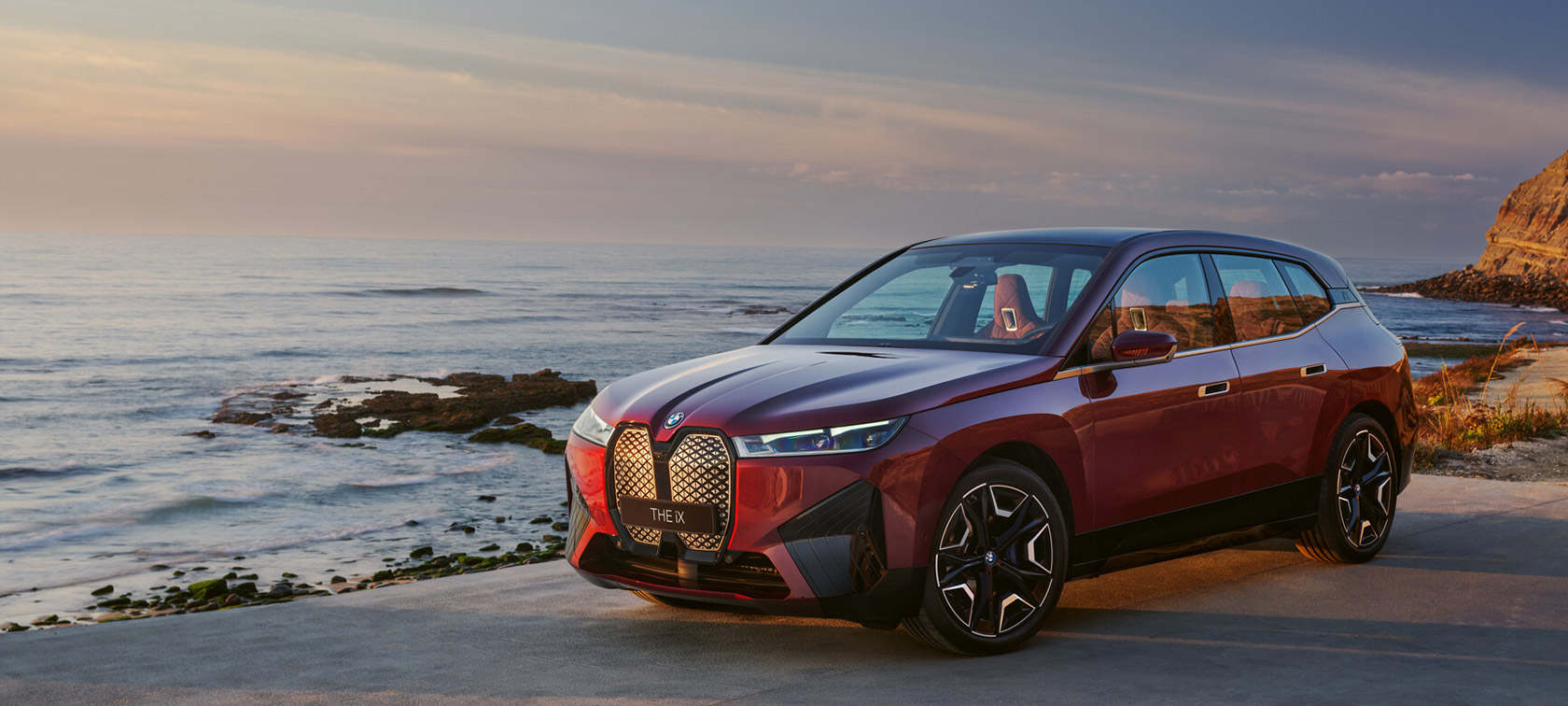BMW iX i20 2021 eldriven SUV BMW iX xDrive50 aventurinröd vid kusten