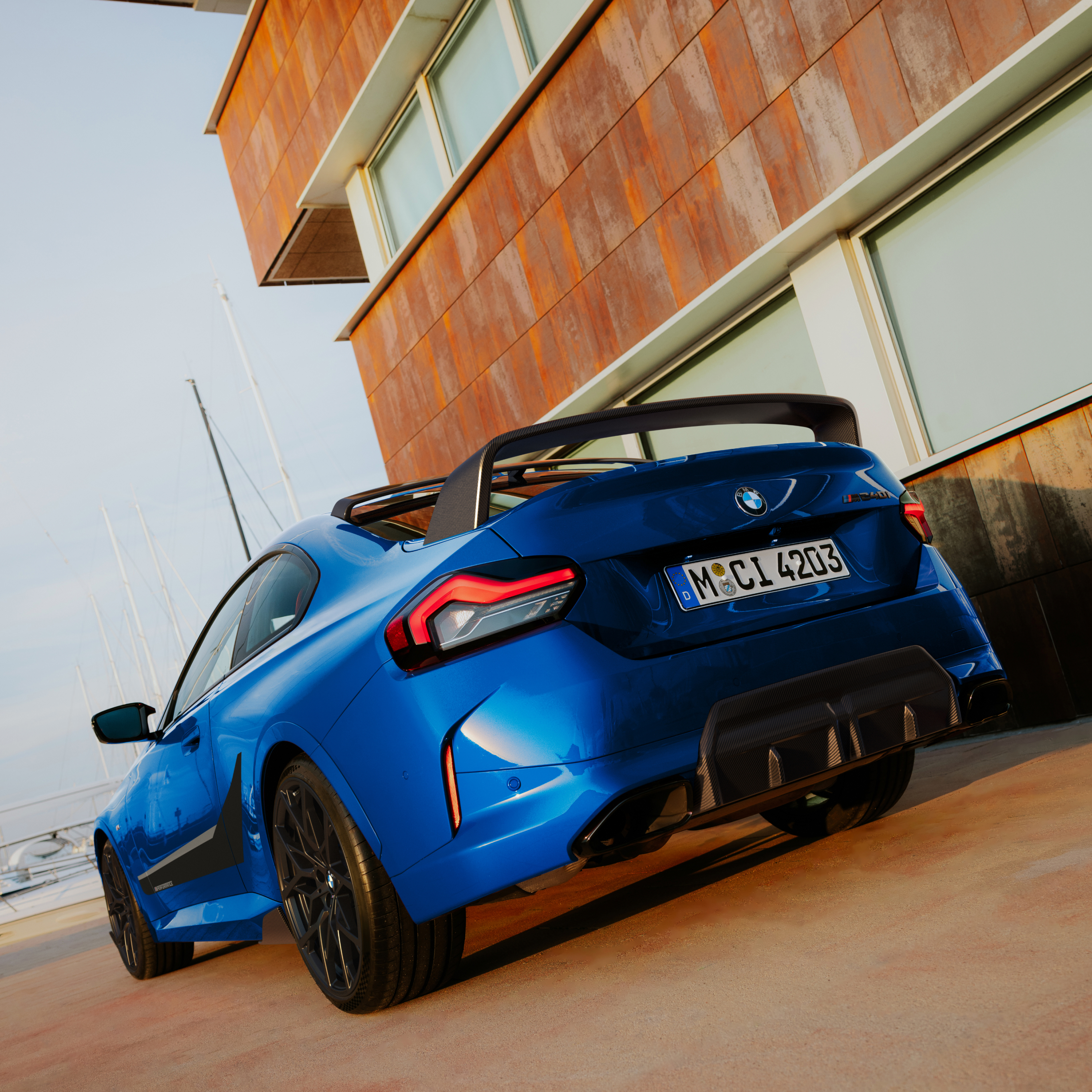 BMW med M Performance bakspoiler parkerad framför ett hus