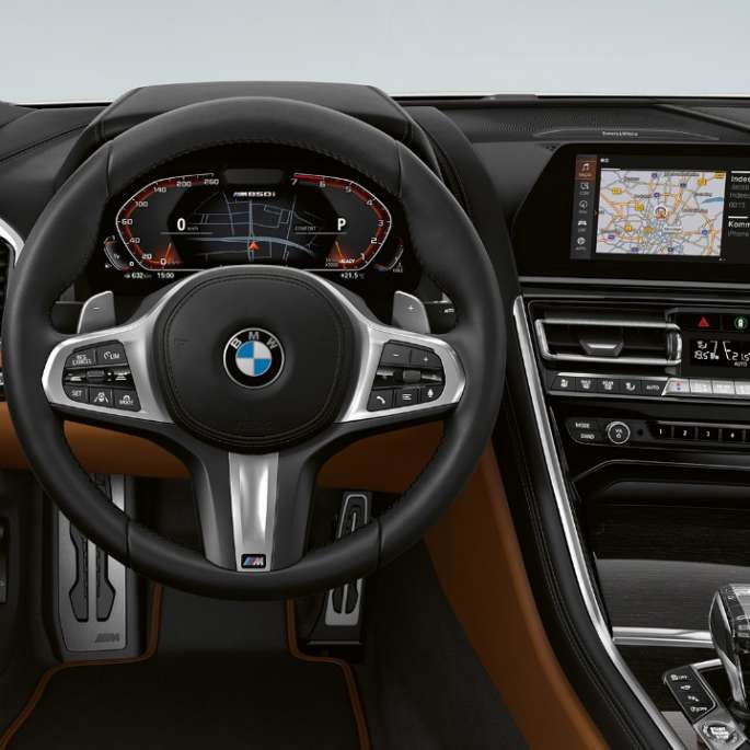 BMW M850i xDrive, Mineral White metallic, förarplats med M lädersportratt.