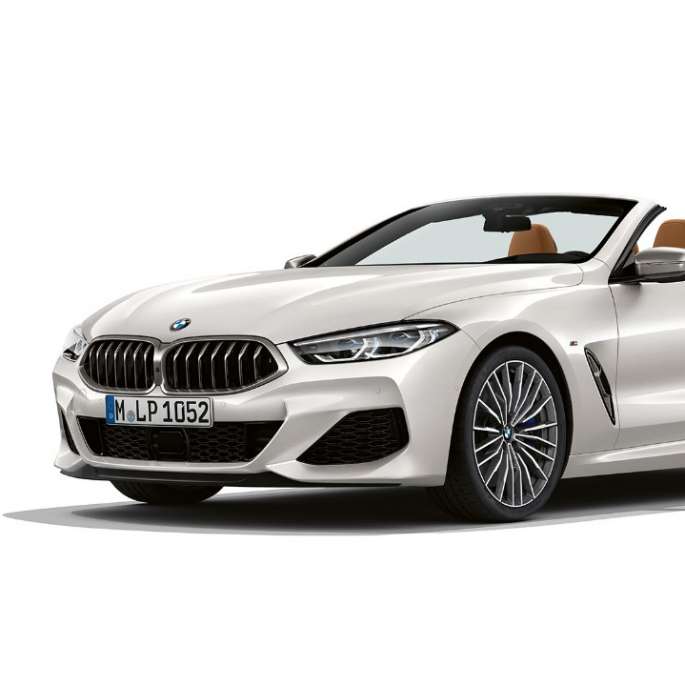BMW M850i xDrive, Mineral White metallic, snett framifrån.