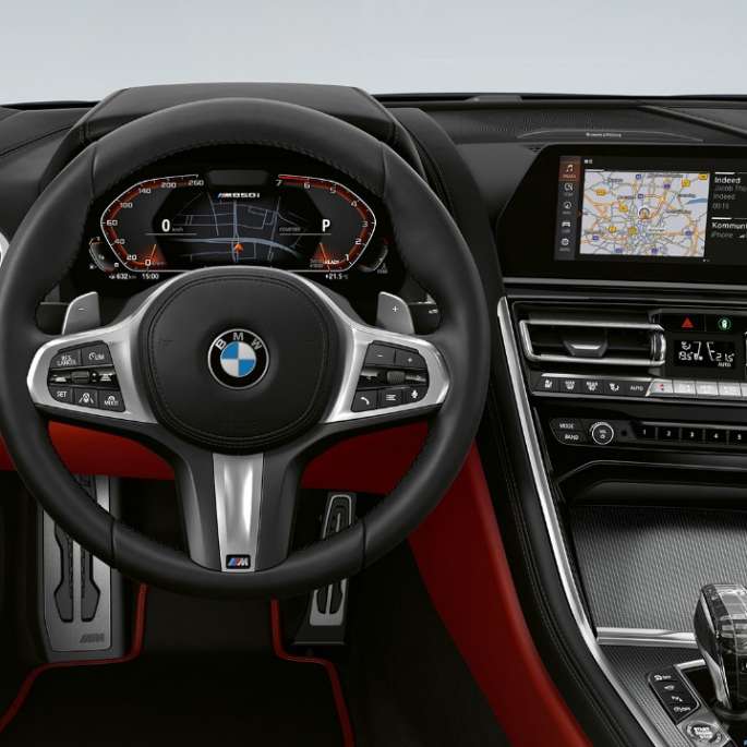 BMW M850i xDrive, Carbon Black metallic, förarplats med M lädersportratt.